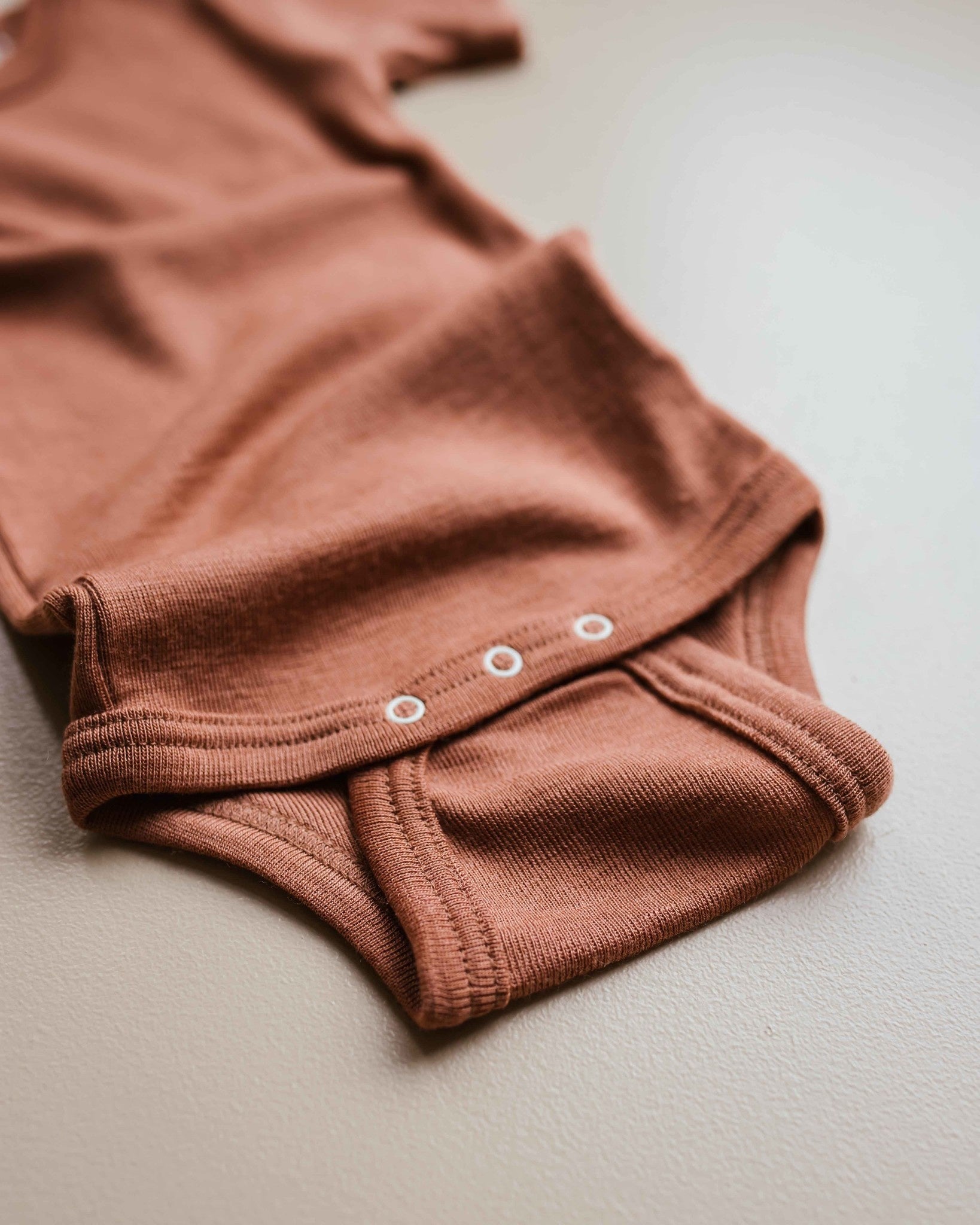 unaduna-sienna-clay-baby-body-short-sleeve-woolsil